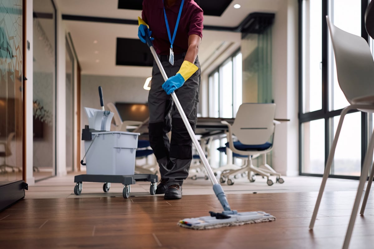 A cleaning professional mopping the floor of a commercial space
