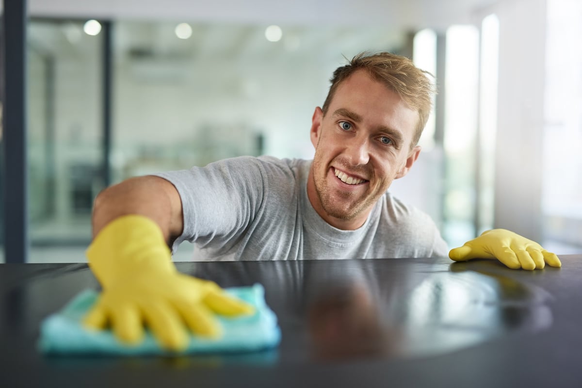 A cleaning professional wiping down surfaces in a bright, well-kept space