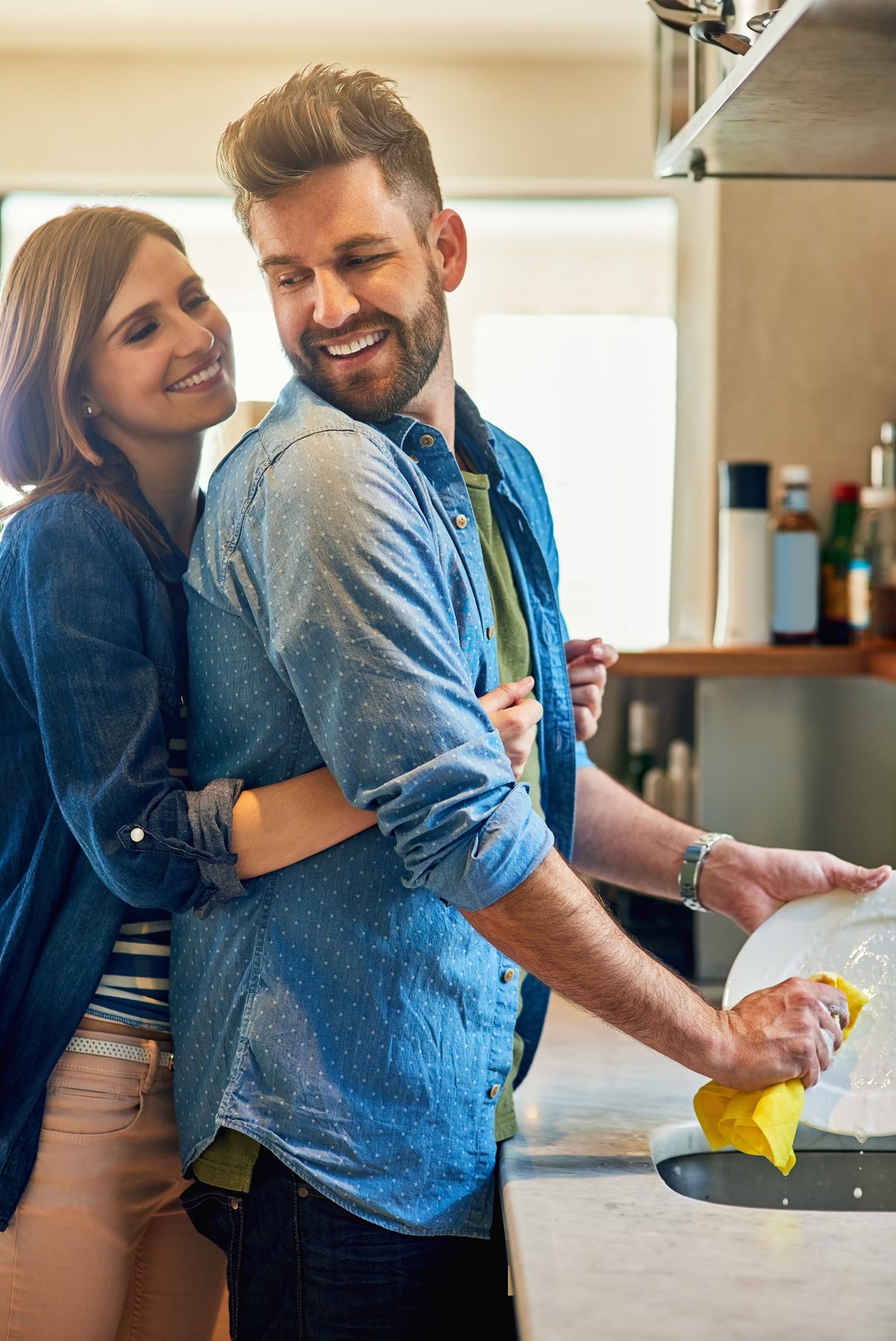 A couple smiling together while sharing household chores at home